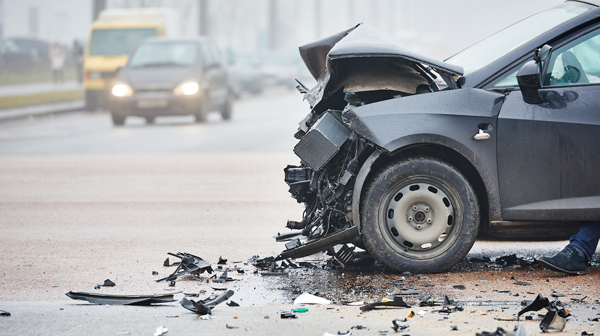 Black vehicle with front-end damage due to a collision