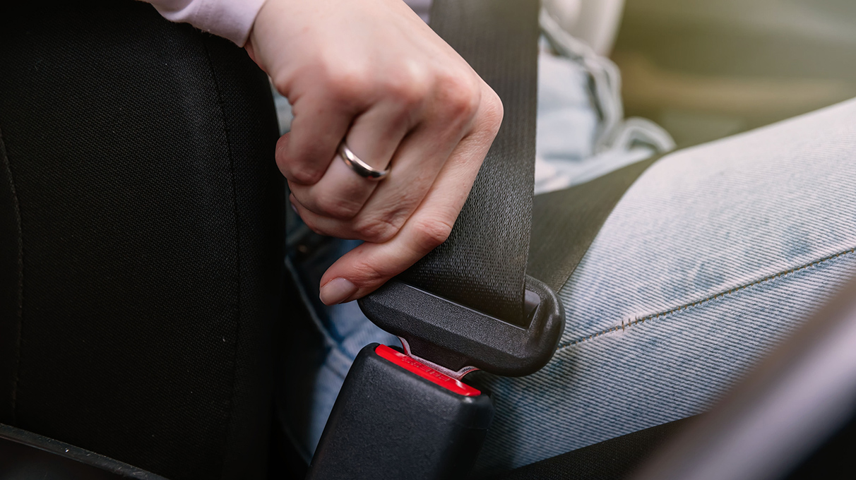 Close up of someone putting on their seatbelt