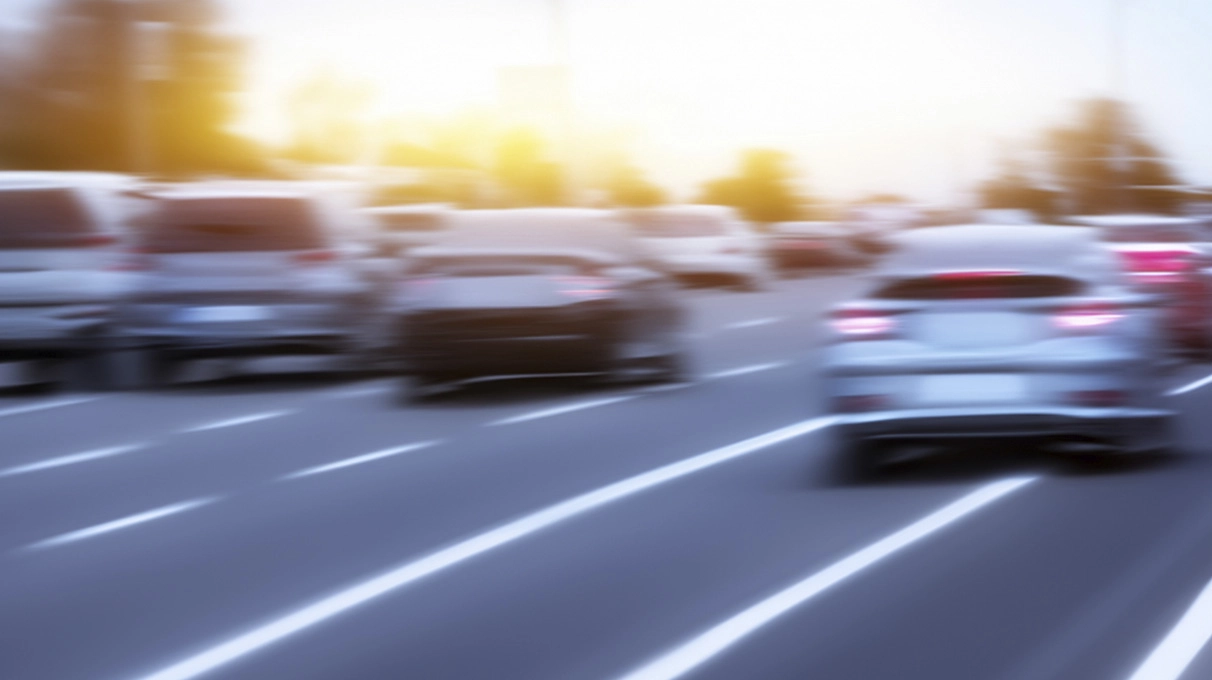 Several cars driving on highway, with blurred effect to showcase movement