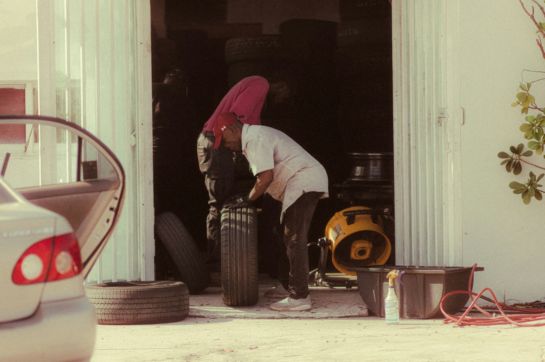 Mechanic inspecting a vehicle tire in a repair garage.